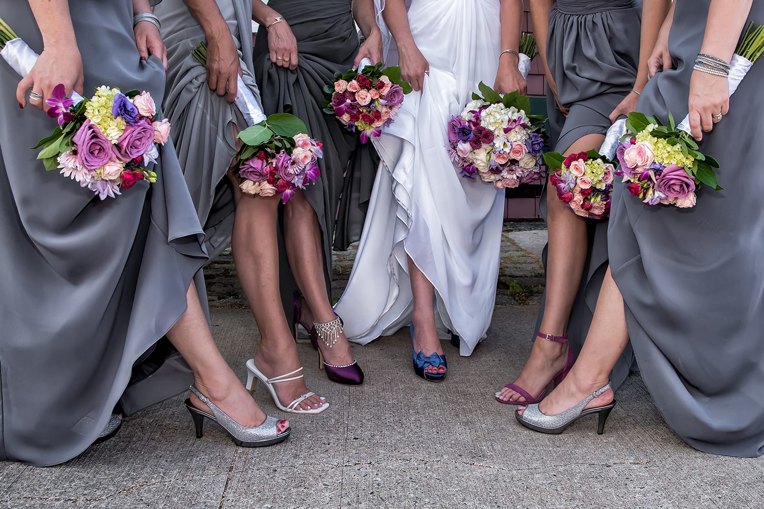 The bride with bridesmaids show off their legs and their wedding shoes at the Historic Properties in Halifax.