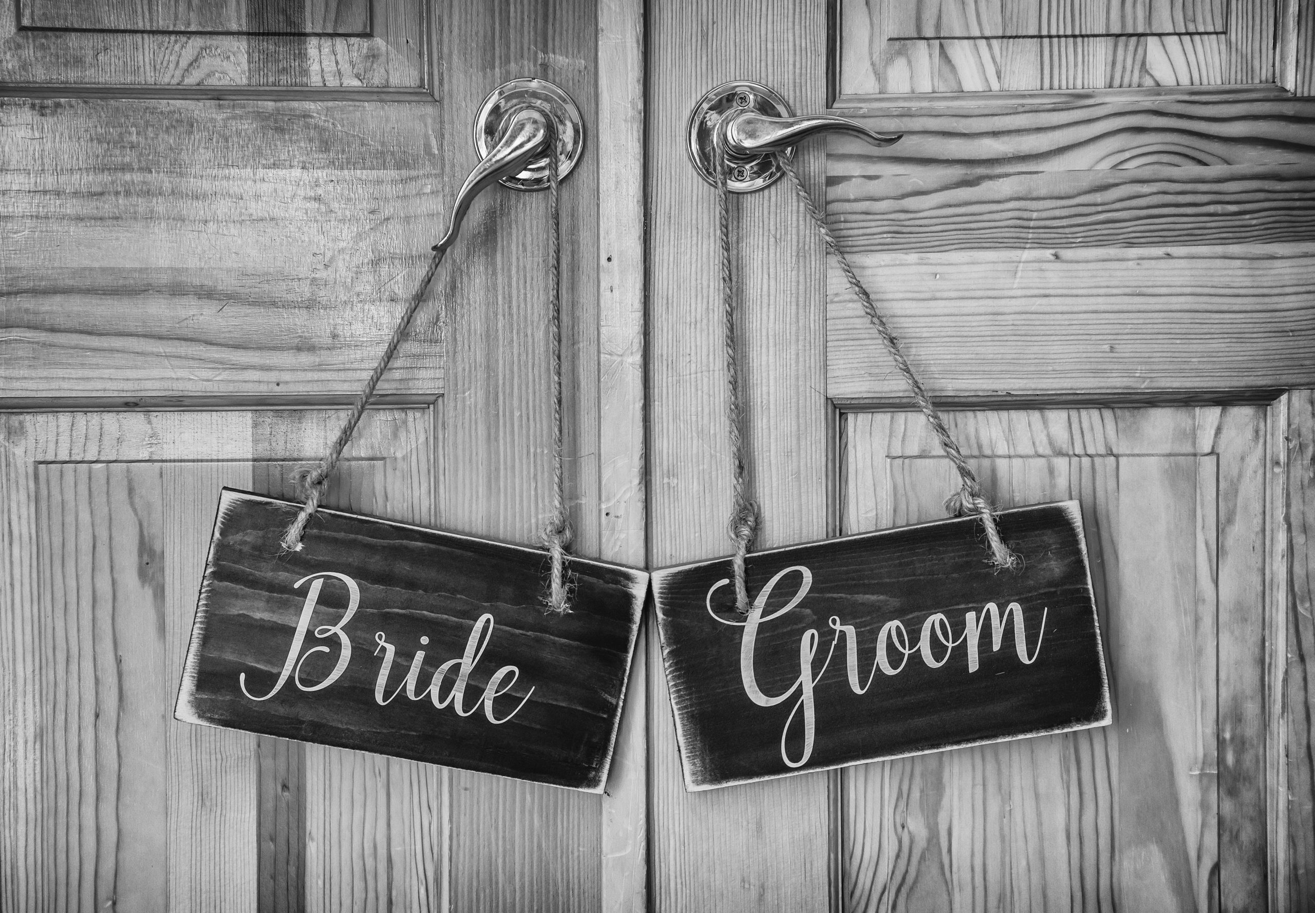 Bride and groom wooden signs for chairs at a wedding.
