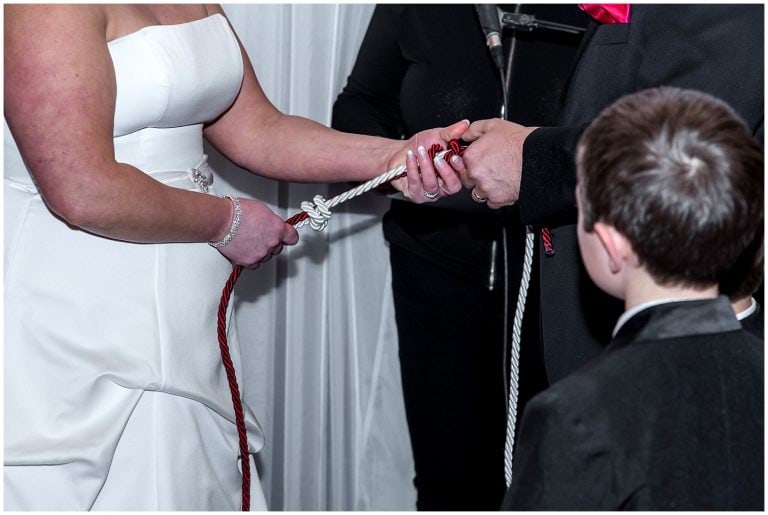 The bride and groom tie a fishermans knot or lovers knot during their wedding ceremony at the Lower Deck Tap Room in Halifax, NS.