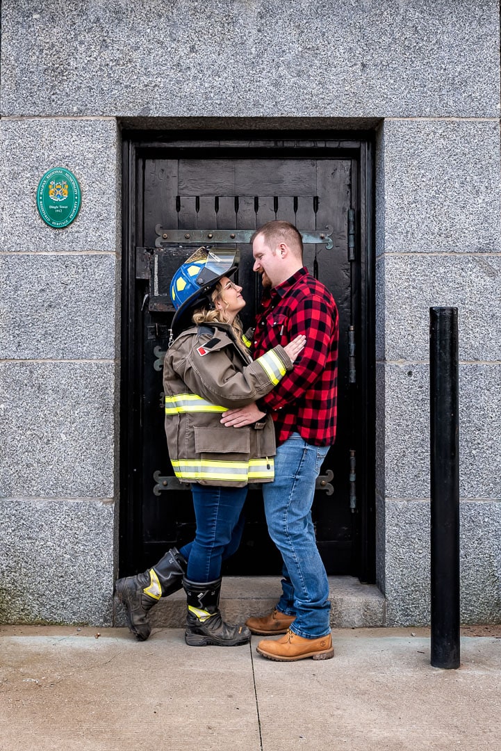 Couple in love pose for fireman engagement photos at the Dingle Tower in Halifax, NS.