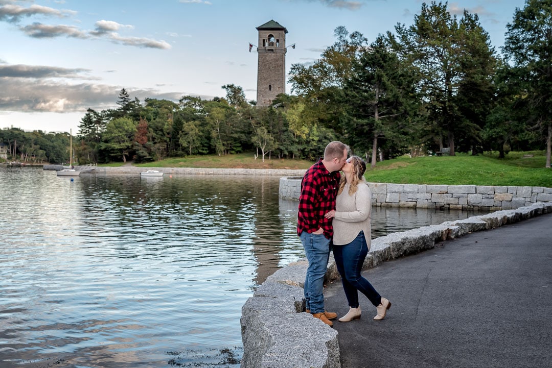 A cute couple in love and newly engaged embrace during their engagement photography shoot at the Sir Sandford Fleming Park in Halifax, NS.