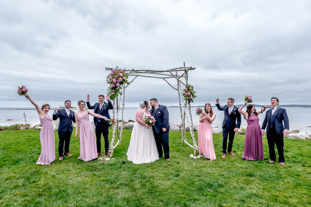 The bride and groom pose for fun wedding party photos during their wedding at Oceanstone Resort in Nova Scotia.