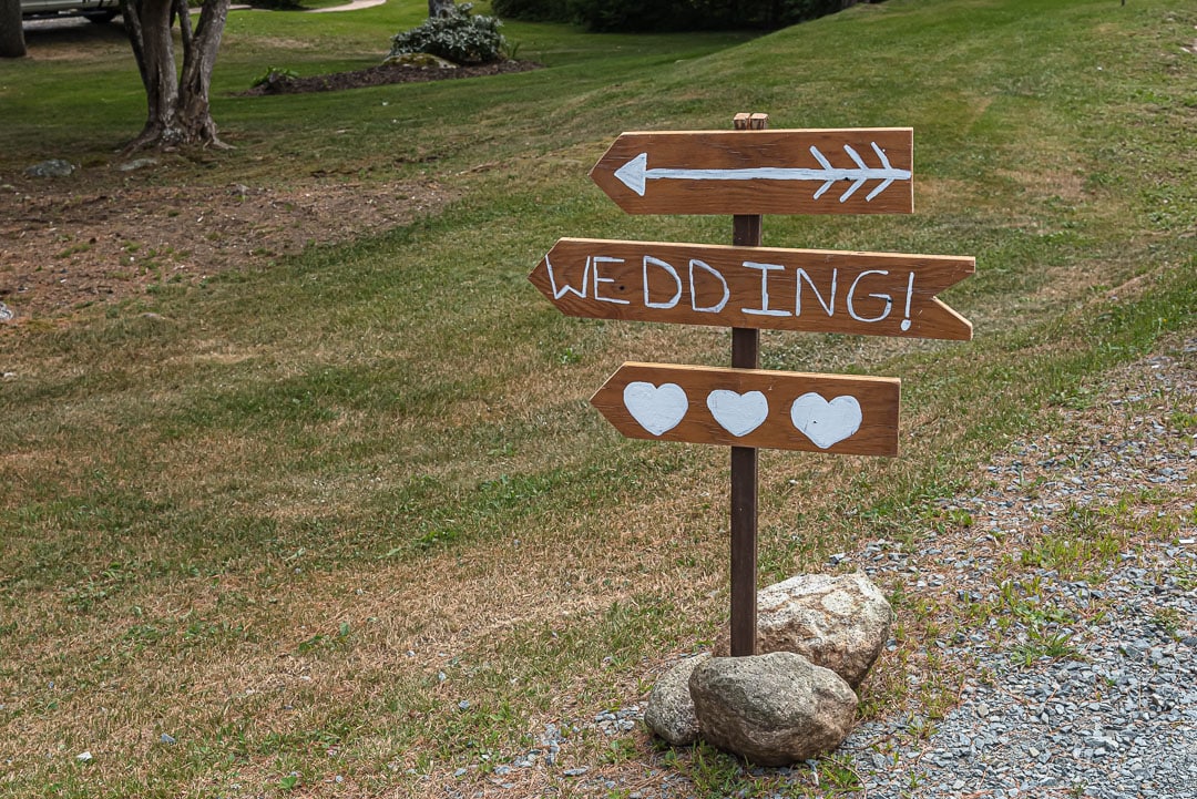 A rustic wooden wedding sign to direct guests to the wedding ceremony on the ocean in Halifax, NS.