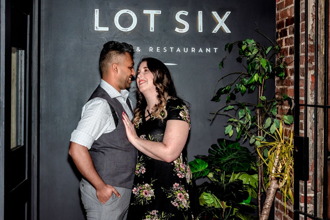 A newly engaged couple smile at each other during their engagement shoot at the Lot 6 Bar and Restaurant in Halifax, NS.