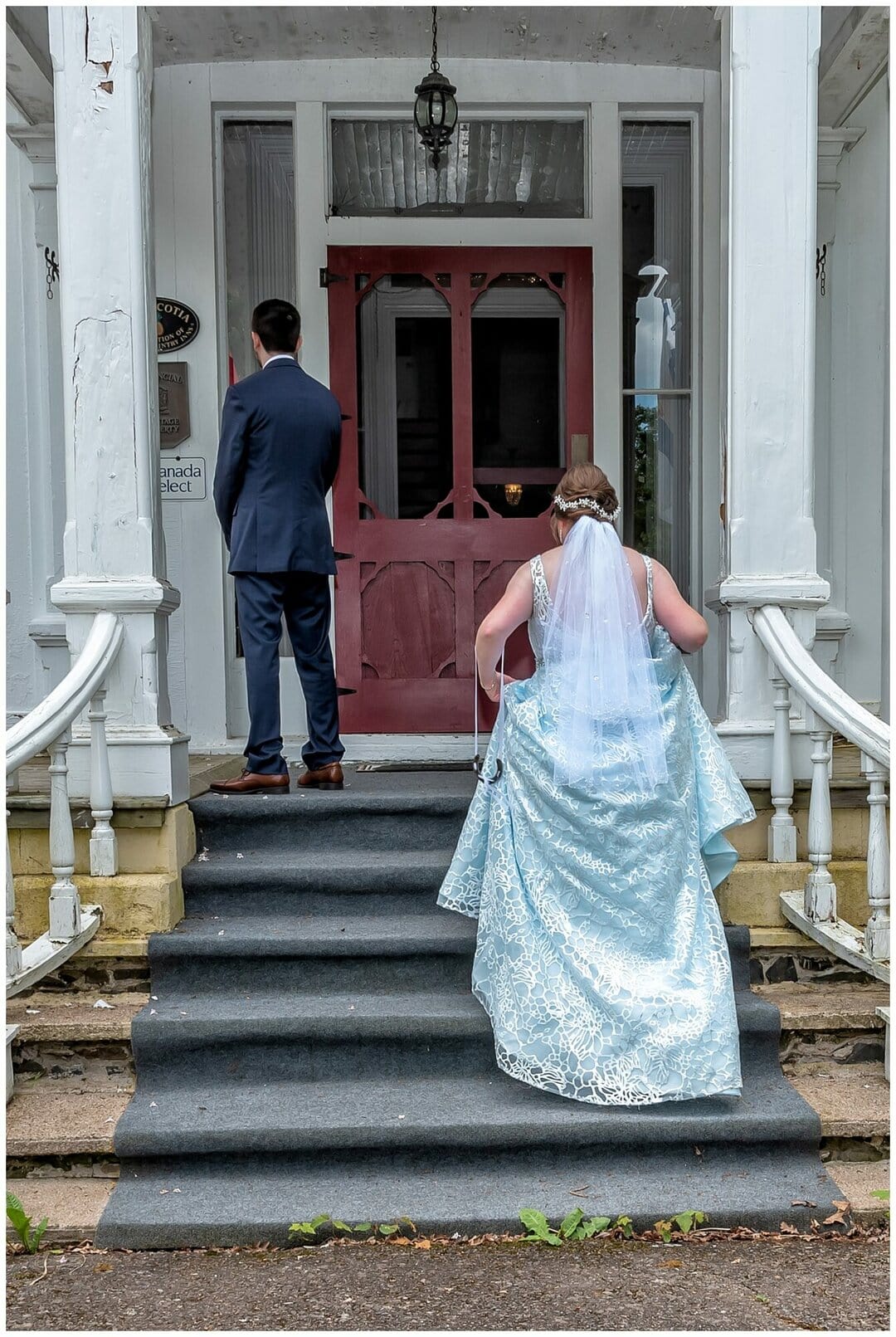 The bride climbs the stairs to tap her soon to be husband on the shoulder for their wedding first look at the Hillsdale House in Annapolis Royal NS.