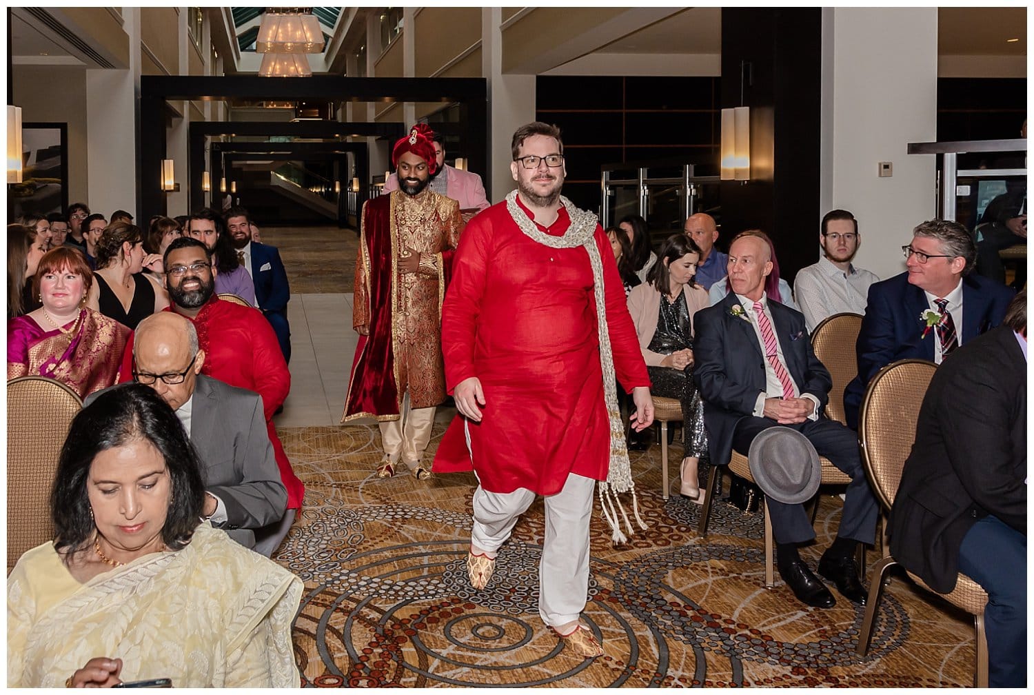 The groom walks up the aisle to stand by the officiant during his wedding ceremony at the Halifax Marriott Harbourfront Hotel.