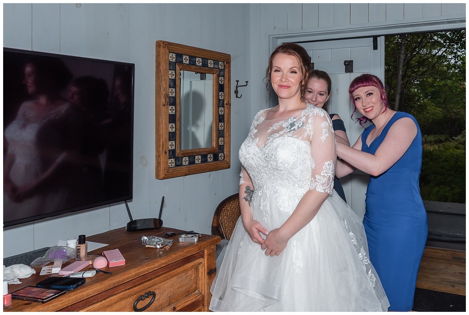 The bridesmaids help the bride into her wedding gown during bridal prep at an air bnb in Halifax.