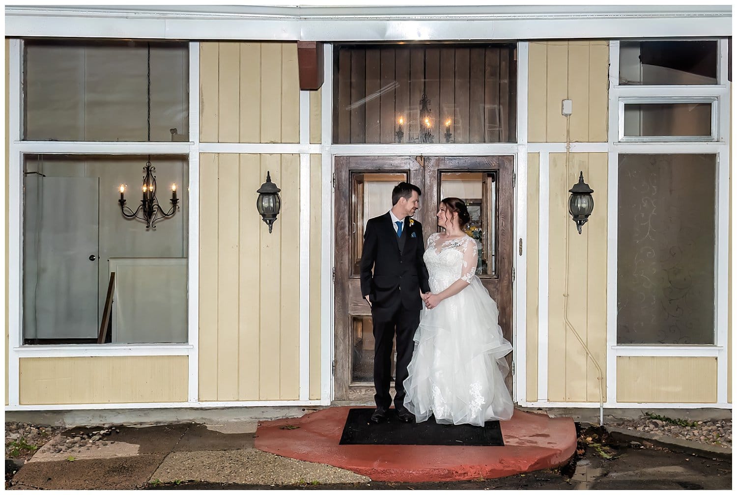 The bride and groom pose in front of the Saraguay House for romantic elegant wedding photos.