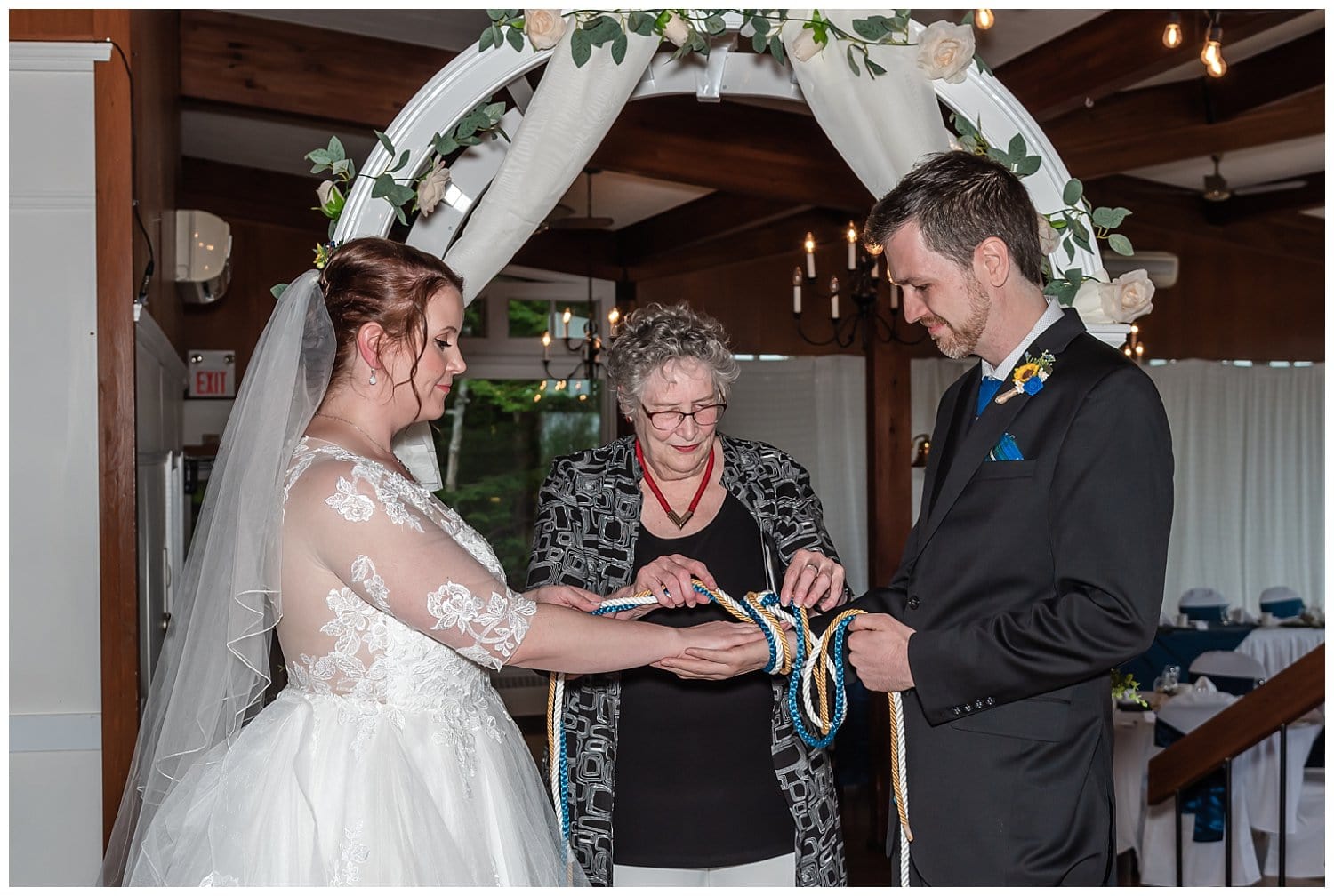 The bride and groom celebrate by having a handfasting knot tying ceremony during their wedding,