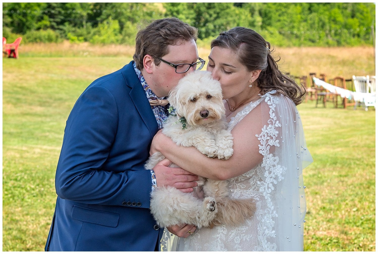 The bride and groom cuddle with their dog Nova during their first look before their wedding ceremony.