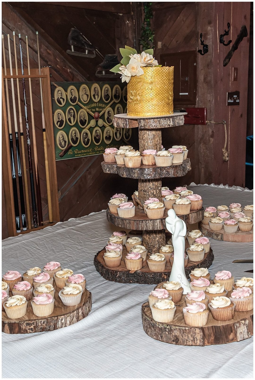 A rustic yellow wedding cake with cupcakes.