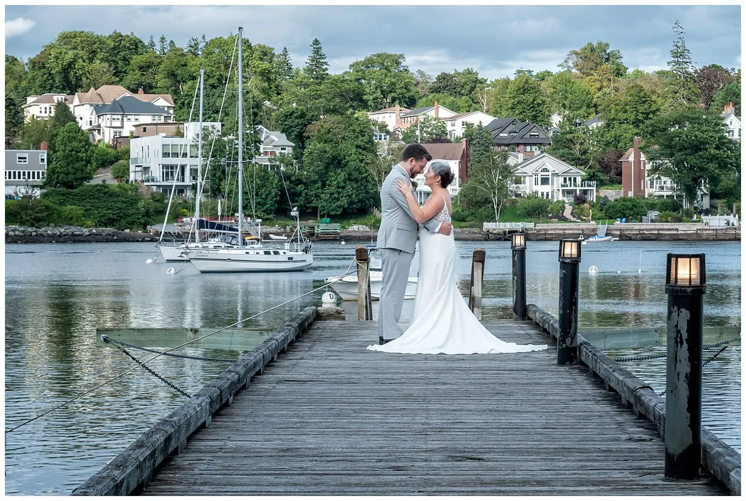 The bride and groom pose for their wedding photos on the wharf at Saraguay House overlooking the ocean.