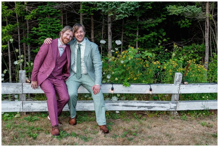 The LGBT grooms pose on a fence during their wedding photos at the Hubbards Campground and Cottages in NS.
