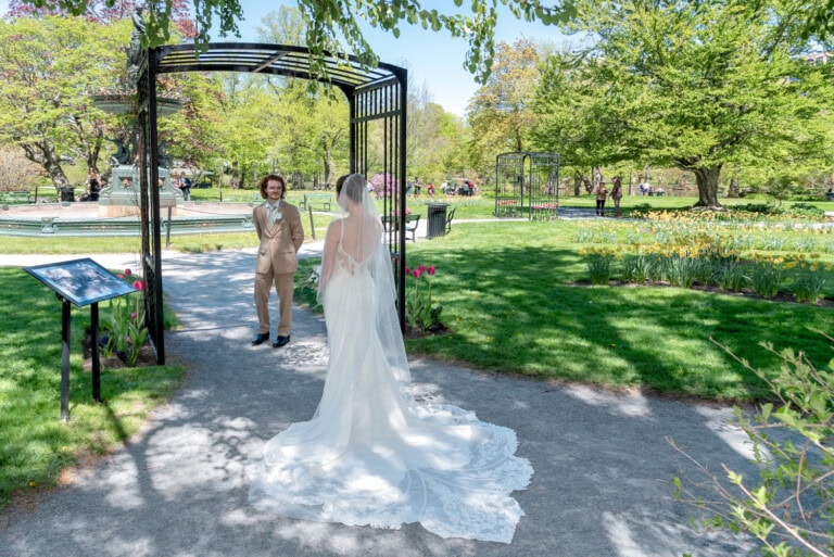Bride and groom sharing their first look in the Halifax Public Gardens surrounded by spring greenery.