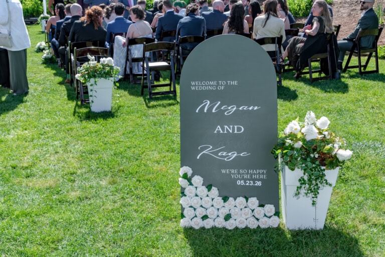 Wedding welcome sign for Megan and Kage displayed at Ashburn Golf Club in Halifax with guests seated behind it.