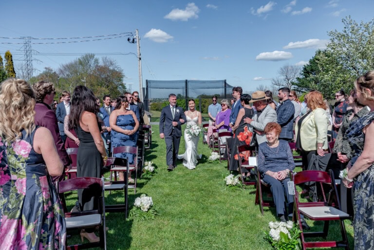 Bride walking down the aisle with her father during the outdoor ceremony at Ashburn Golf Club in Halifax.
