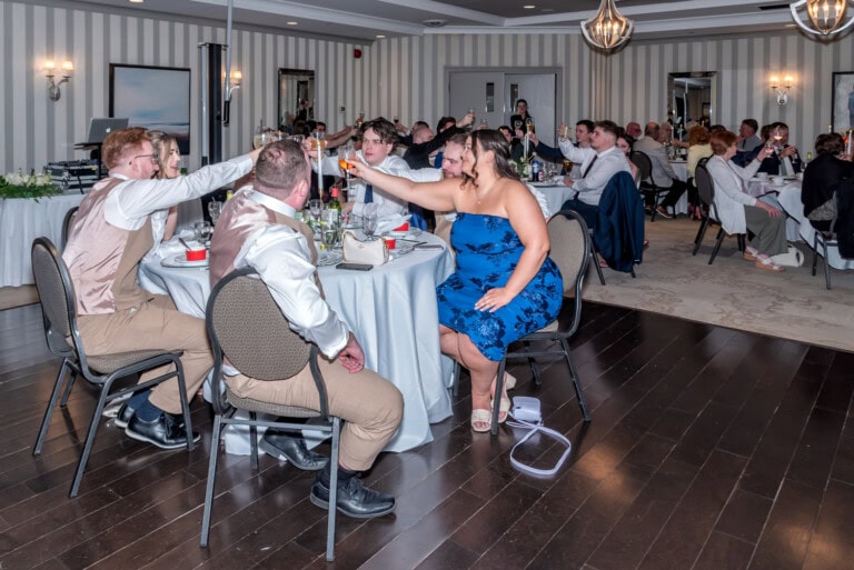Wedding guests raising glasses in a celebratory toast during the reception at Ashburn Golf Club.