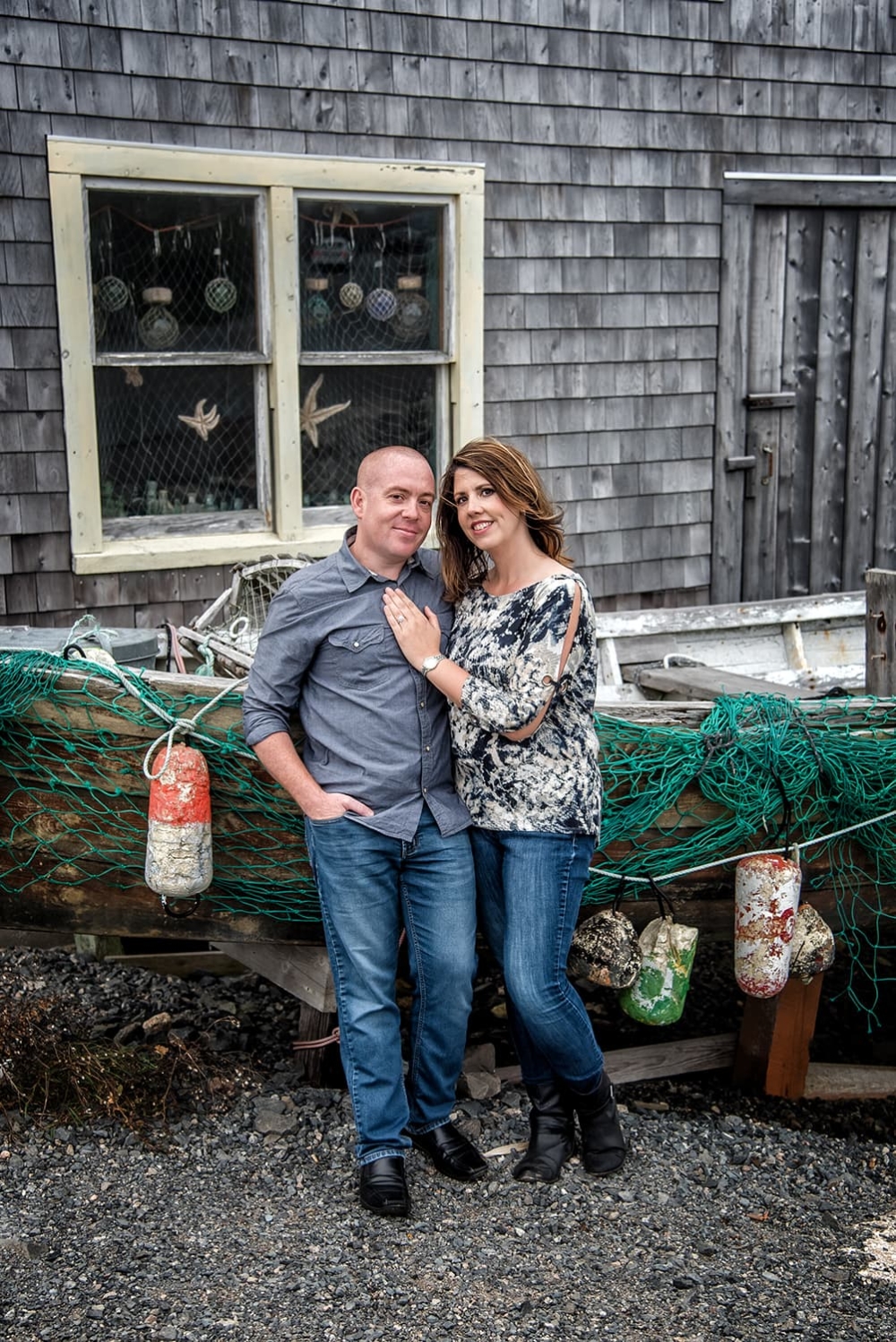 Engagement Portfolio Page Engagement photos of a couple in love standing infront of a fishing boat at Peggys Cove, NS.