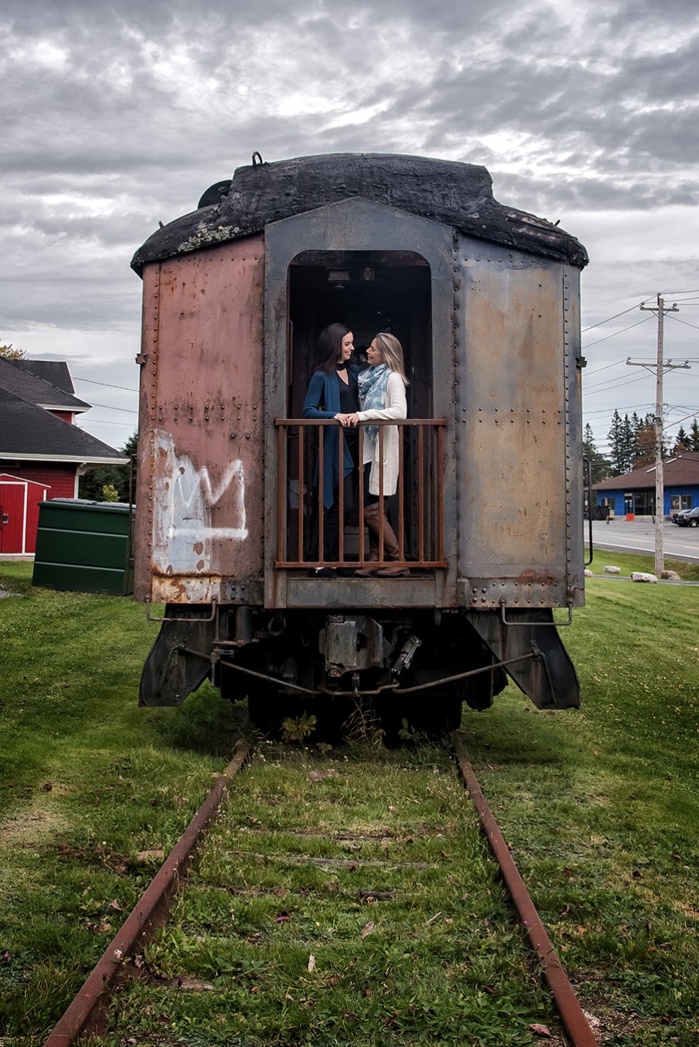 Engagement Portfolio Page An LGBT lesbian couple on a train during engagement photos at the Musquodoboit Train Museum in Nova Scotia.