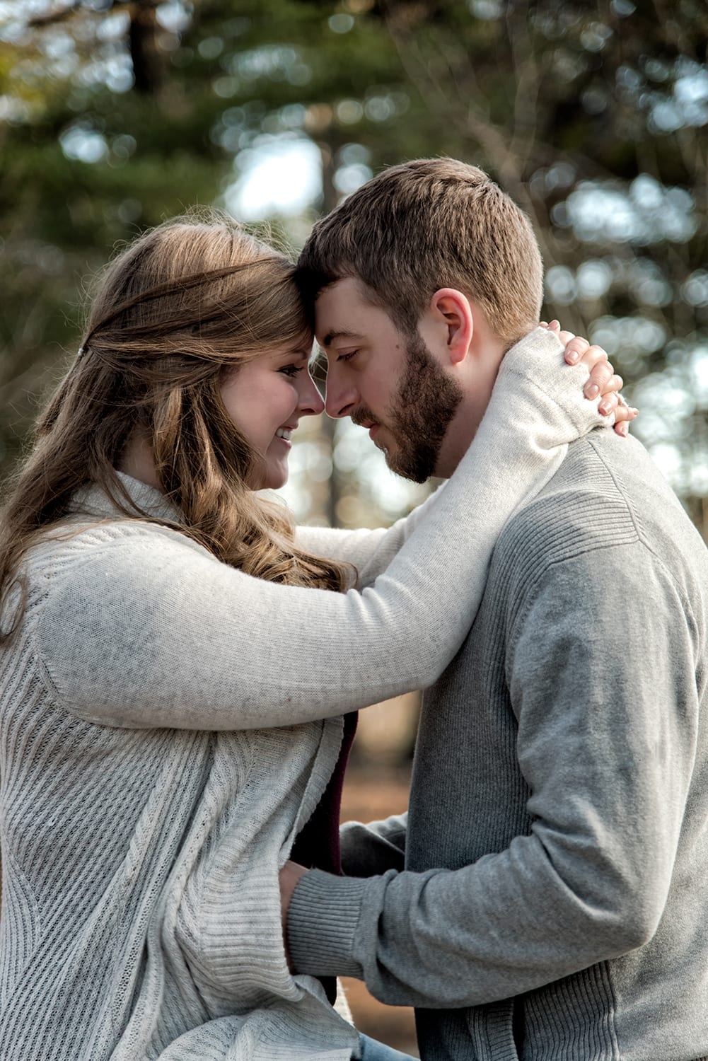 Engagement Portfolio Page A couple forehead to forehead during their engagement photo session at Point Pleasant Park in Halifax, NS.