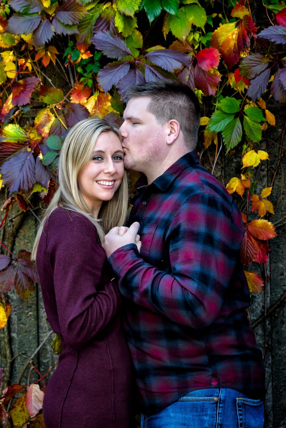 Cute couple poses for their engagement shoot surrounded by autumn leaves in the Historic Properties in Halifax, NS.
