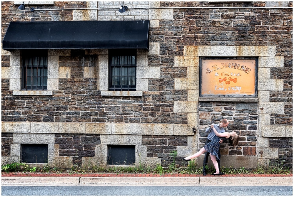 A newly engaged couple, he dips her while she laughs during their engagement photos at the Historic Properties in Halifax NS.